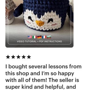 May include: A handmade crochet penguin basket pattern. The basket is navy blue and white, with a yellow beak and black eyes. The text "CROCHET PENGUIN BASKET PATTERN" is at the top. The text "VIDEO TUTORIAL + PDF INSTRUCTIONS" is at the bottom.