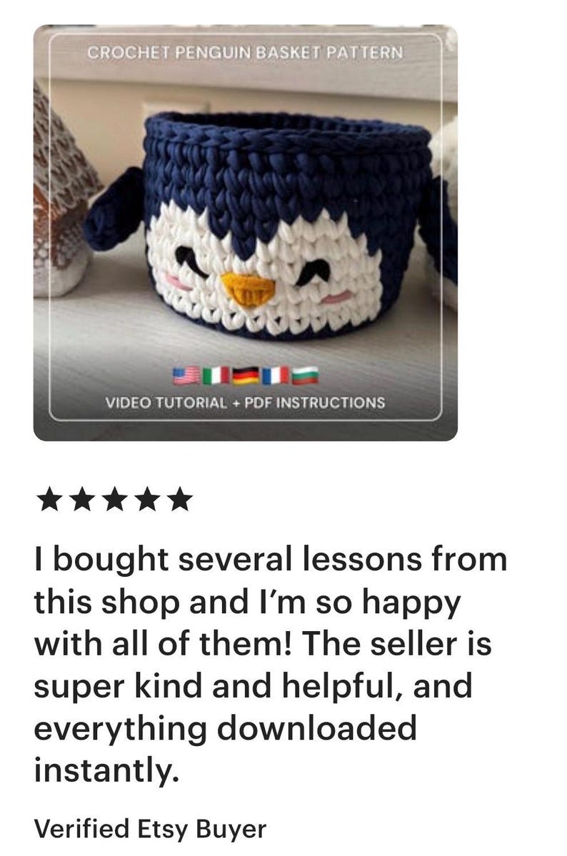 May include: A handmade crochet penguin basket pattern. The basket is navy blue and white, with a yellow beak and black eyes. The text "CROCHET PENGUIN BASKET PATTERN" is at the top. The text "VIDEO TUTORIAL + PDF INSTRUCTIONS" is at the bottom.