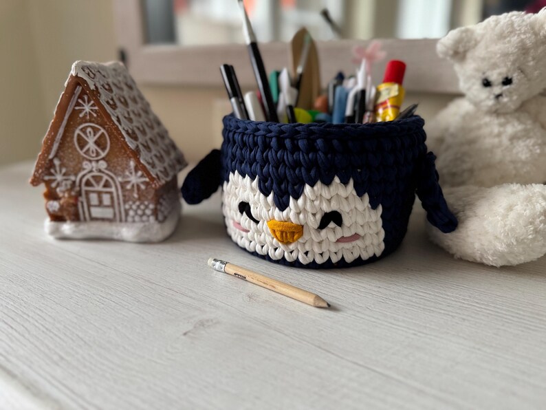 Crochet basket tutorial, penguin crochet basket pattern, easy crochet video class, beginner crochet course, t-shirt yarn basket, crochet home decor, handmade Christmas gift idea, kids room storage basket, holiday crochet pattern, crochet for beginners, crochet pattern PDF, step-by-step crochet tutorial, crochet wooden base basket, DIY crochet decor, multilingual crochet course, crochet basket design 2025, crochet craft idea, crochet digital download.