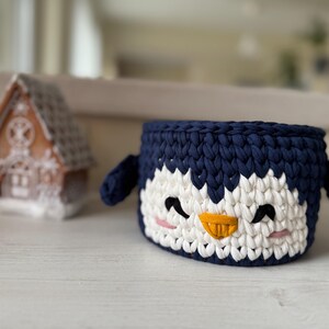 Crochet basket tutorial, penguin crochet basket pattern, easy crochet video class, beginner crochet course, t-shirt yarn basket, crochet home decor, handmade Christmas gift idea, kids room storage basket, holiday crochet pattern, crochet for beginners, crochet pattern PDF, step-by-step crochet tutorial, crochet wooden base basket, DIY crochet decor, multilingual crochet course, crochet basket design 2025, crochet craft idea, crochet digital download.