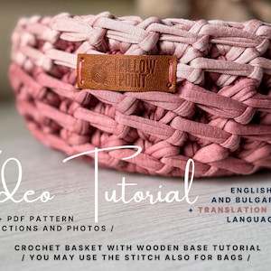 May include: A handmade crochet basket in shades of pink, with a woven texture. The basket features a leather tag with the text "PILLOW POINT". The image includes text that says "Video Tutorial".