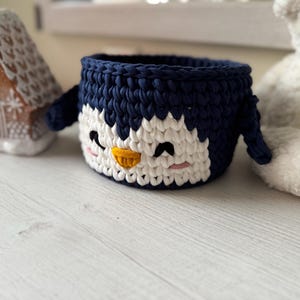 Crochet basket tutorial, penguin crochet basket pattern, easy crochet video class, beginner crochet course, t-shirt yarn basket, crochet home decor, handmade Christmas gift idea, kids room storage basket, holiday crochet pattern, crochet for beginners, crochet pattern PDF, step-by-step crochet tutorial, crochet wooden base basket, DIY crochet decor, multilingual crochet course, crochet basket design 2025, crochet craft idea, crochet digital download.