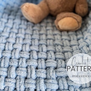 May include: A close-up of a light blue, woven-style blanket with a teddy bear's foot visible in the upper right corner. The blanket has a textured, chunky knit appearance. A white circle with the words "Crochet PATTERN PDF&VIDEO" is in the lower right corner.