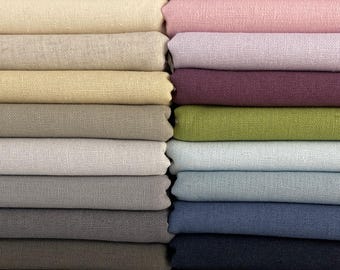 May include: A stack of fabric swatches in various shades of beige, pink, purple, green, blue, and gray. The fabric is a linen blend.