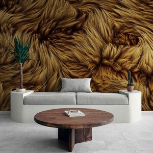 May include: A modern living room featuring a light gray sofa, a round wooden coffee table, and a textured brown and gold wall. Decorative plants in white pots add a touch of greenery. The floor is tiled.