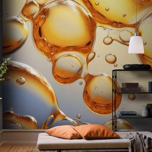 May include: Abstract wall mural featuring large, translucent, amber-colored bubbles against a soft, gradient background. The bubbles have a glossy appearance, with highlights and shadows. The scene includes a bench with orange pillows, a black metal shelf, and two white pendant lights.