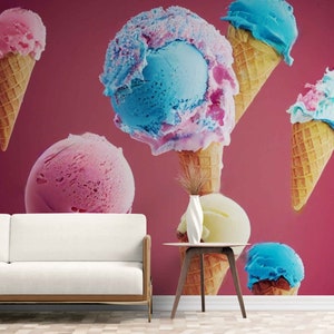 Könnte beinhalten: Rosa, blaue und gelbe Eiswaffeln vor einem rosafarbenen Hintergrund. Die Eiswaffeln schweben in der Luft. Im Vordergrund befindet sich ein weißes Sofa und ein kleiner Tisch.