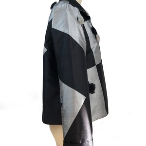 May include: A black and silver jacket with a geometric pattern and floral embellishments.