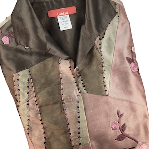 K&ouml;nnte beinhalten: Eine braune, gr&uuml;ne und rosafarbene Seidenbluse mit Perlenbesatz und Blumenstickerei. Die Bluse hat einen Kragen und einen Knopfleisten vorne. Das Etikett lautet "LisBeth" und "Small".