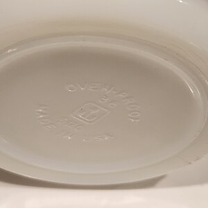May include: White, oven-proof dish with a rounded base. The bottom of the dish is light gray and features the text "OVEN-PROOF", "38", and "MADE IN U.S.A.". The dish has a simple, classic design.