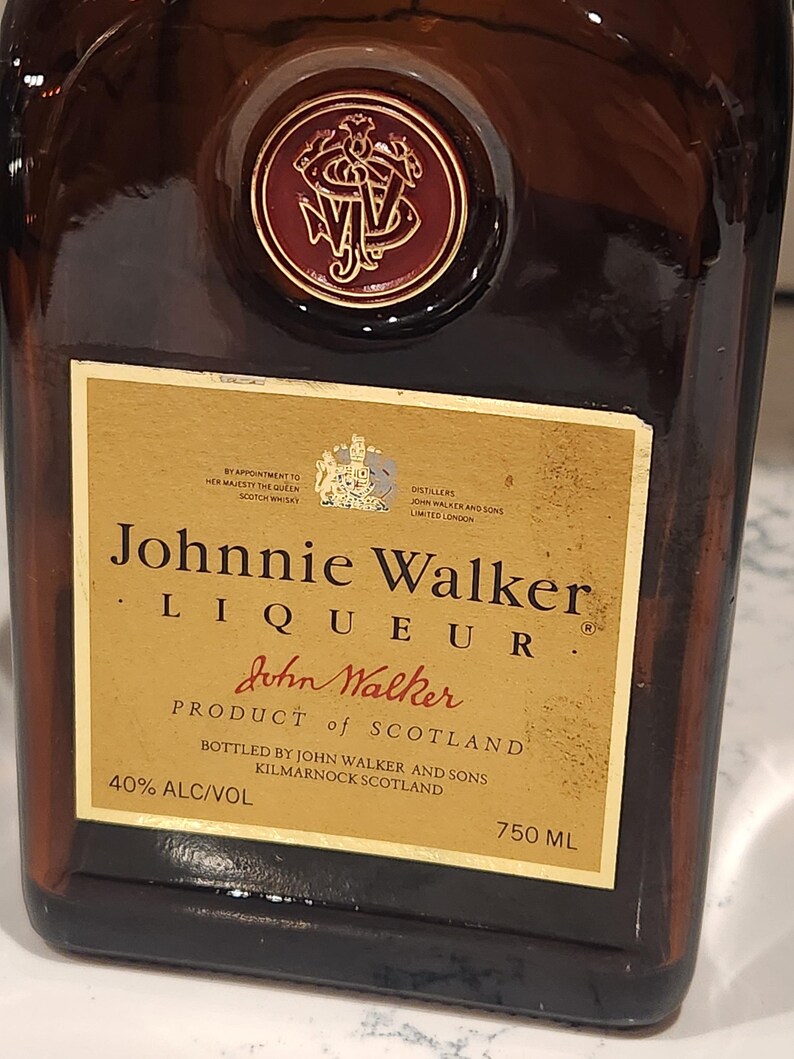 Pode incluir: Uma garrafa de vidro castanho de licor Johnnie Walker. O r&oacute;tulo &eacute; dourado com texto preto, incluindo "Johnnie Walker" e "Product of Scotland". A garrafa cont&eacute;m 750 ml de licor e tem 40% de &aacute;lcool.