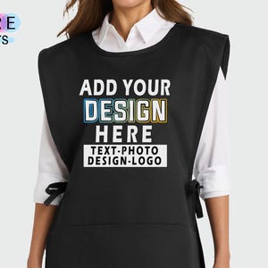 May include: Black apron with a large front pocket and side ties. The apron features the text "ADD YOUR DESIGN HERE TEXT-PHOTO DESIGN-LOGO" in white. The words "MORE colors" are in the upper left corner.