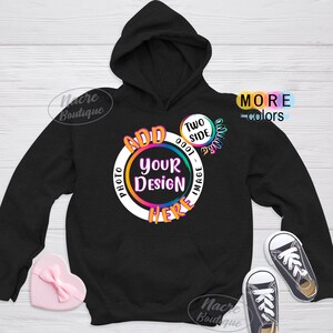 May include: Black hooded sweatshirt with a white circle design that says "Add Your Design Here" in rainbow colours. The circle also has the text "Two Side Printing" and "Photo - Image" in smaller text. The sweatshirt is on a white wooden background.