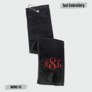 a black towel with a red monogram on it, and there is a text embroidery on the towel.
