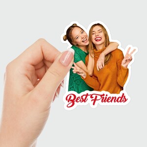 Puede incluir: Dos mujeres sonriendo y abraz&aacute;ndose, vistiendo camisas verdes y naranjas. El texto "Best Friends" est&aacute; escrito en rojo debajo de la imagen.
