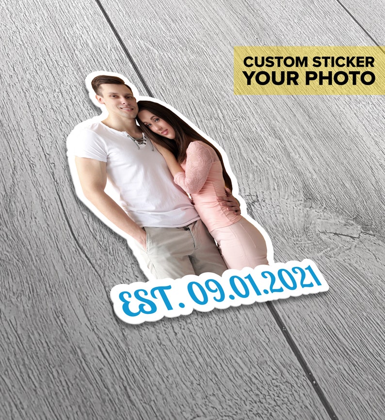 Puede incluir: Una pegatina personalizada con una foto de una pareja, el hombre lleva una camiseta blanca y pantalones caqui, la mujer lleva una camisa rosa y una falda. La pegatina tiene el texto "EST. 09.01.2021" y las palabras "CUSTOM STICKER YOUR PHOTO" en un recuadro amarillo.