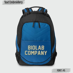 May include: Black and blue backpack with the text "BIOLAB COMPANY" embroidered in gold. The backpack has a padded back and shoulder straps. The top handle and zipper pulls are black. The text "Text Embroidery" is above the backpack and "FONT: #5" is below.