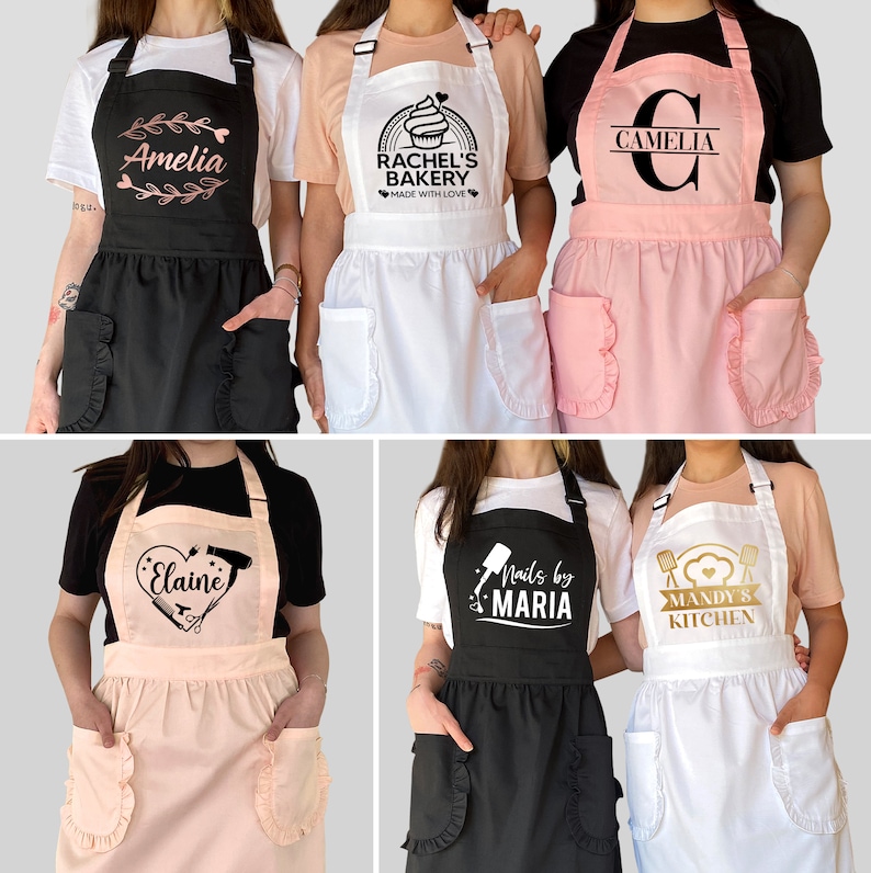 Puede incluir: Seis delantales personalizados con diferentes dise&ntilde;os y nombres. Los delantales son negros, blancos y rosas con bordes con volantes. Los dise&ntilde;os incluyen una magdalena, un coraz&oacute;n con corta&uacute;&ntilde;as y un secador de pelo, una letra C, un coraz&oacute;n con un batidor y un rodillo, una botella de esmalte de u&ntilde;as y un batidor y un coraz&oacute;n.