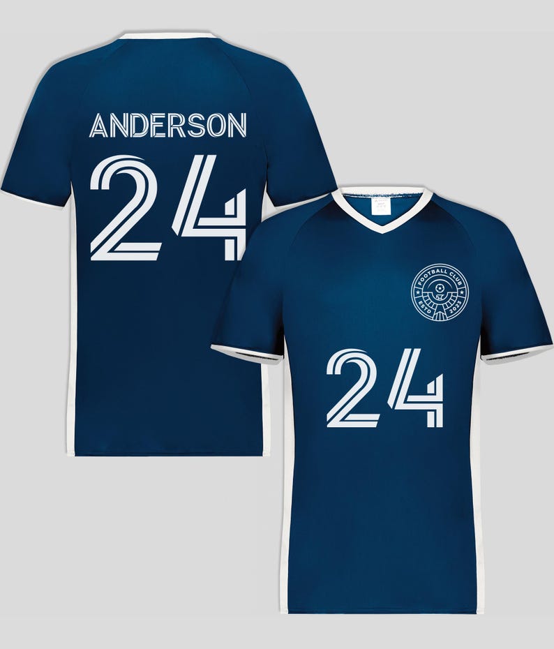 May include: Navy blue soccer jersey with white trim and the number 24 in white. The back of the jersey displays the name "ANDERSON" above the number 24. A football club logo is on the front.