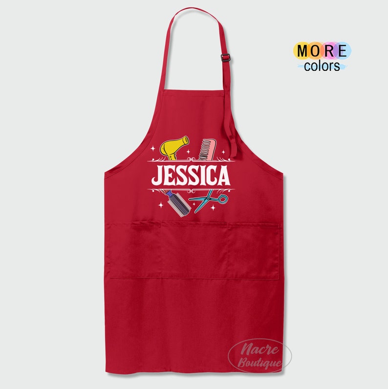 Puede incluir: Delantal rojo con un dise&ntilde;o blanco de herramientas de peluquer&iacute;a y el nombre "JESSICA".