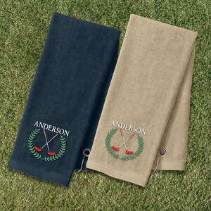 Two towels, one blue and one beige, are placed on a grassy surface.