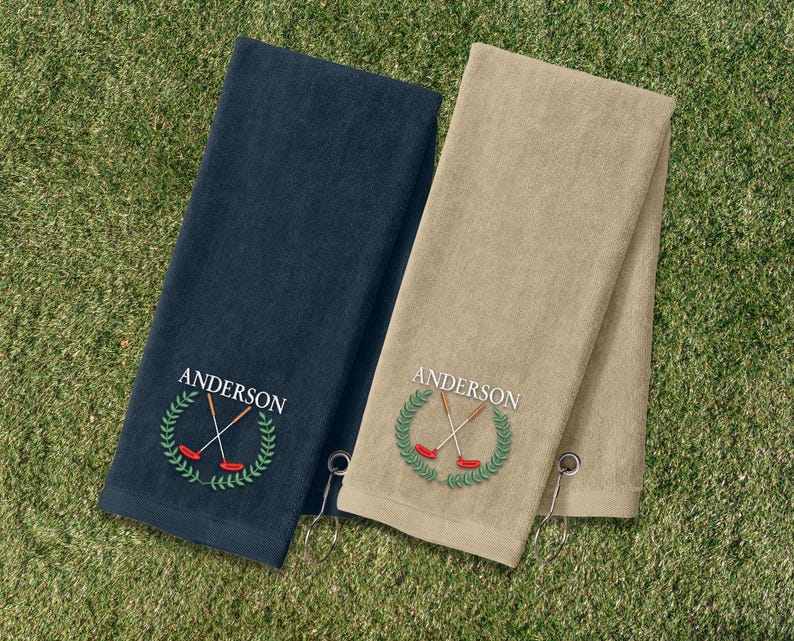 Two towels, one blue and one beige, are placed on a grassy surface.