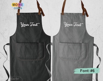 May include: Two aprons with brown neck straps and waist ties. One apron is black and the other is gray. Both feature a large front pocket and the white text Your Text embroidered on the chest. The image includes the text MORE colors and Font: #6.