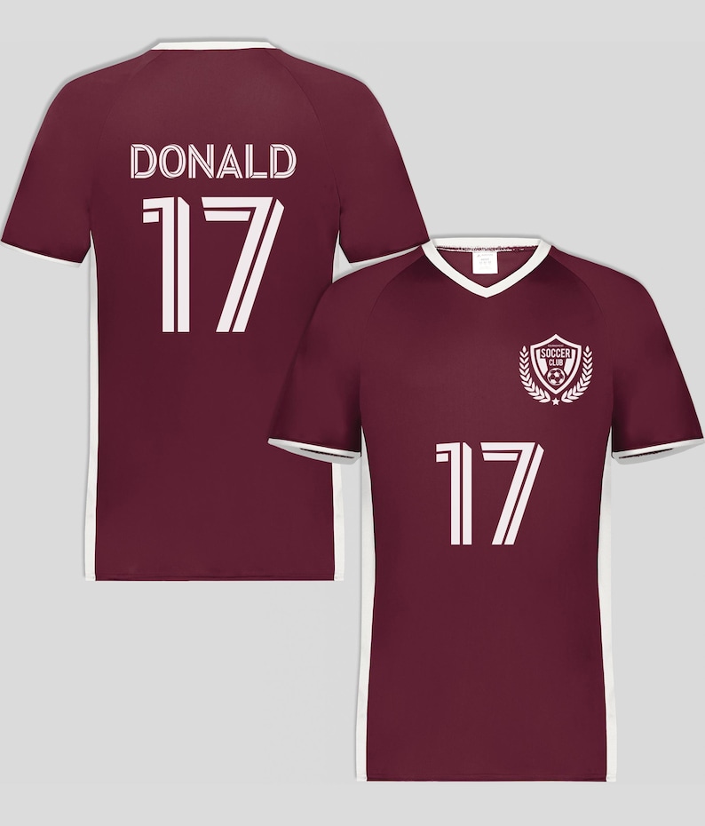 May include: Maroon soccer jersey with white trim and the number 17. The back of the jersey displays the name "DONALD" above the number 17. The front features a "SOCCER CLUB" emblem and the number 17.