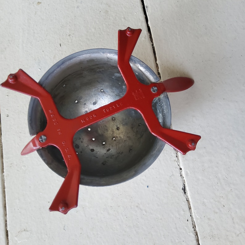 K&ouml;nnte beinhalten: Roter Metallsieb mit Griff und Sch&uuml;ssel. Das Sieb ist mit "Made in U.S.A." und "Cook Sure All" beschriftet.