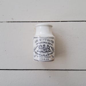 Könnte beinhalten: Weiße Keramikdose mit einem schwarz-weißen Etikett mit der Aufschrift "Anchovy Paste for Sandwiches &c. Prepared by Crosse & Blackwell 21 Soho Square London."