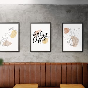 May include: Three framed prints with minimalist line drawings and watercolor accents. The left print features a coffee pot pouring coffee into a glass carafe. The middle print says "but first, coffee". The right print features a stylized coffee cup with a heart.
