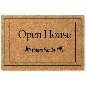 K&ouml;nnte beinhalten: Eine braune Kokosmatte mit schwarzem Rand und dem Text "Open House Come On In" in schwarzen Buchstaben.