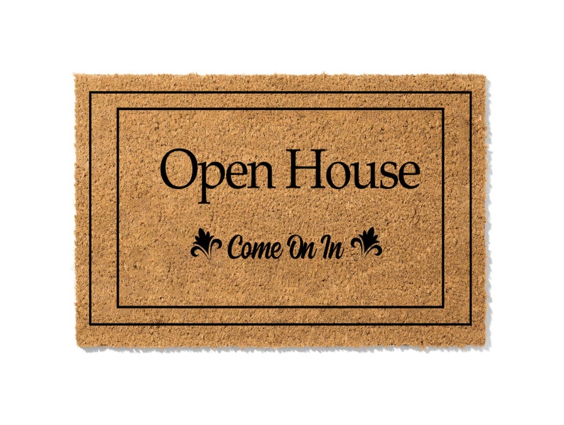 K&ouml;nnte beinhalten: Eine braune Kokosmatte mit schwarzem Rand und dem Text "Open House Come On In" in schwarzen Buchstaben.