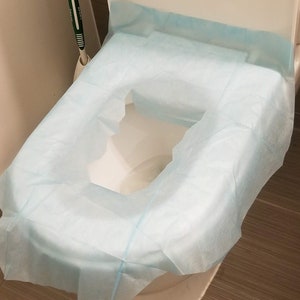 May include: A white toilet seat with a light blue disposable toilet seat cover.