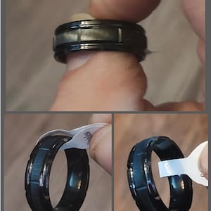 Op de afbeelding: Een zwarte en zilveren ring met een getextureerde band. De ring is gemaakt van metaal en heeft een gepolijste afwerking.