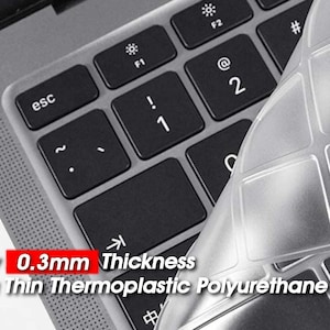 Könnte beinhalten: Eine transparente, dünne Tastaturabdeckung aus thermoplastischem Polyurethan. Die Abdeckung ist für eine Laptop-Tastatur konzipiert und nur 0,3 mm dick. Die Abdeckung ist teilweise über einer Laptop-Tastatur angebracht, wobei der Text "Only 0.3mm Thickness Ultra Thin Thermoplastic Polyurethane" sichtbar ist.