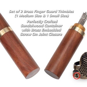 May include: Set of two brass finger guard thimbles, one small and one medium, in a sandalwood container with a brass screw-on closure. The container is open and the thimbles are visible. The thimbles are both brass and have a honeycomb pattern. The small thimble has an 'S' engraved on it and the medium thimble has an 'M' engraved on it.