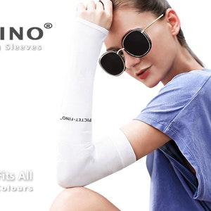 May include: White arm sleeves with the text "PICTET FINO® Sun Block and Cooling Sleeves" on them. The sleeves are worn by a person wearing a blue shirt and sunglasses. The text "Free Size - One Size Fits All Available in Five (5) Colours" is also visible.
