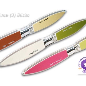 Puede incluir: Un juego de tres limas de uñas con superficies de diferentes colores. Cada lima tiene un paso diferente para el cuidado de las uñas: acortar, limar, corregir, dar brillo, pulir y limpiar. Las limas están etiquetadas con los pasos y están empaquetadas en una caja de plástico transparente.