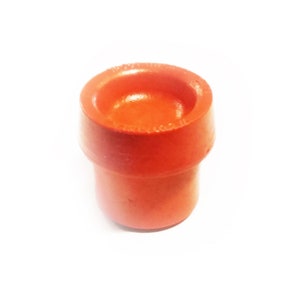 May include: A bright orange plastic bottle stopper. The stopper has a round top and a cylindrical base.