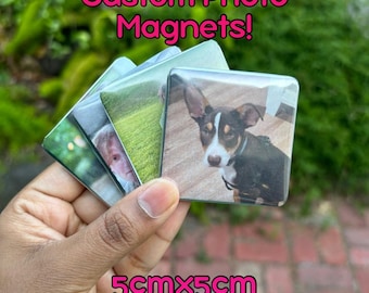 May include: A set of four custom photo magnets, each measuring 5cm x 5cm. The magnets feature different images, including a dog, a child, and a landscape. The magnets are made of clear plastic and have a glossy finish.