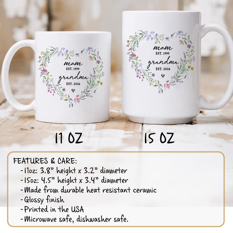 K&ouml;nnte beinhalten: Wei&szlig;e Keramikbecher mit floralem Herzdesign. Die Becher tragen die W&ouml;rter "Mom" und "Grandma" mit den Jahren 1999 und 2026. Der 11-oz-Becher ist 9,65 cm hoch und hat einen Durchmesser von 8,13 cm, der 15-oz-Becher ist 11,43 cm hoch und hat einen Durchmesser von 8,64 cm.