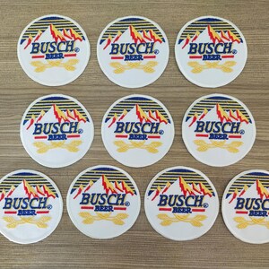 May include: Ten white round patches with a mountain range design and the text "Busch Beer" in red, blue, and yellow.