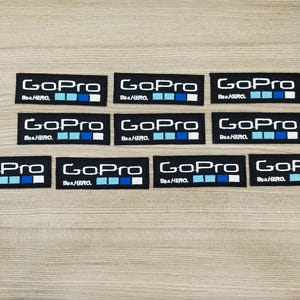 May include: Ten black rectangular patches with white text that reads "GoPro" and "Be a HERO."