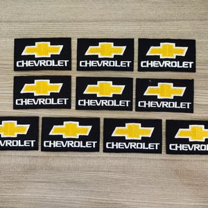 May include: Ten black and yellow embroidered patches with the word "CHEVROLET" in white lettering.