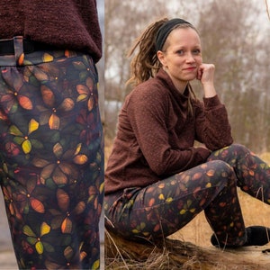 Könnte beinhalten: Eine braune und grüne Hose mit einem Blumenmuster. Die Hose hat einen breiten Bund und eine lockere Passform. Die Hose ist aus einem weichen, bequemen Stoff.