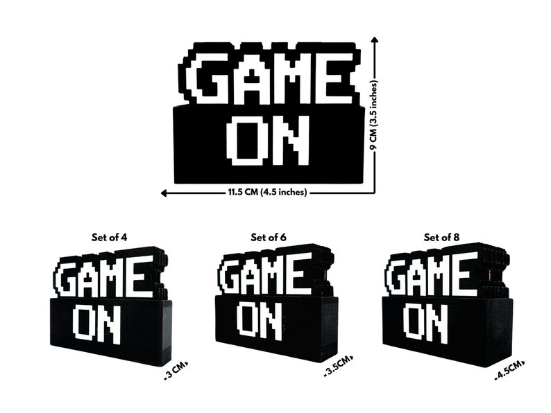 May include: A set of three black and white pixelated "GAME ON" signs. The signs are made of small blocks and come in three sizes: 4, 6, and 8 blocks. The signs are 4.5 inches wide and 3.5 inches tall.