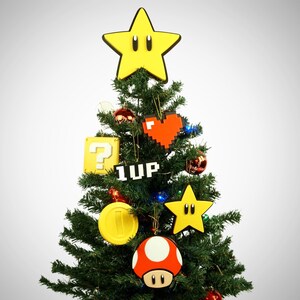 Puede incluir: Un &aacute;rbol de Navidad verde decorado con adornos que representan personajes y objetos de la franquicia de videojuegos Super Mario, incluyendo una estrella amarilla, un coraz&oacute;n rojo, un bloque de signo de interrogaci&oacute;n, un hongo 1-up, una moneda de oro y un hongo rojo.