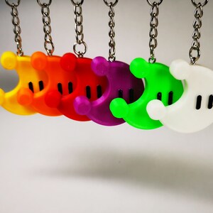 Puede incluir: Un conjunto de siete llaveros en forma de media luna de colores. Los llaveros est&aacute;n hechos de pl&aacute;stico y tienen un contorno negro. Los colores de los llaveros son amarillo, naranja, rojo, morado, verde, blanco y negro.