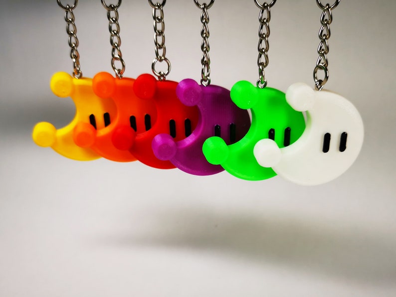 Puede incluir: Un conjunto de siete llaveros en forma de media luna de colores. Los llaveros est&aacute;n hechos de pl&aacute;stico y tienen un contorno negro. Los colores de los llaveros son amarillo, naranja, rojo, morado, verde, blanco y negro.